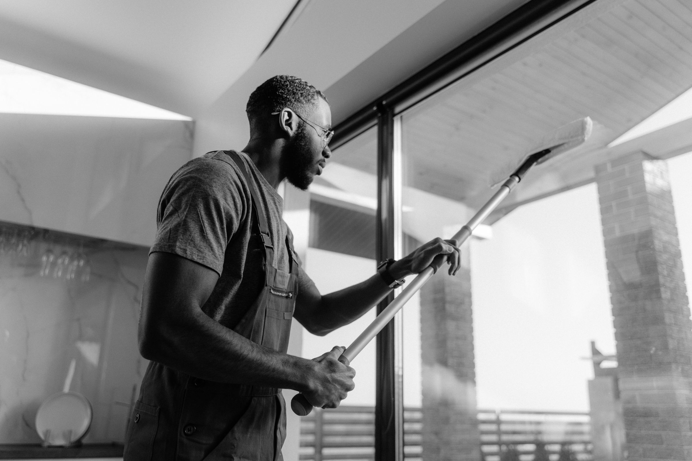 Cleaning professional washing floor-to-ceiling windows in a modern commercial building